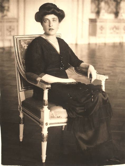 an old photo of a woman sitting in a chair