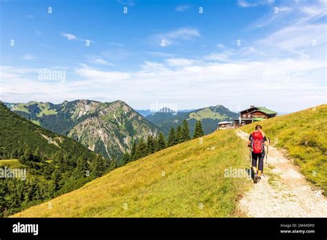 Germany, Bavaria, Female hiker following trail leading to alpine huts in Bavarian Prealps Stock ...