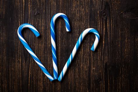 Premium Photo | Blue candy canes on a dark wooden background