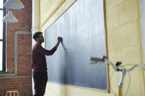 Man Writing on a Blackboard · Free Stock Photo