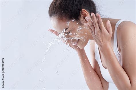 Beautiful woman washing her face in a white background studio Stock ...