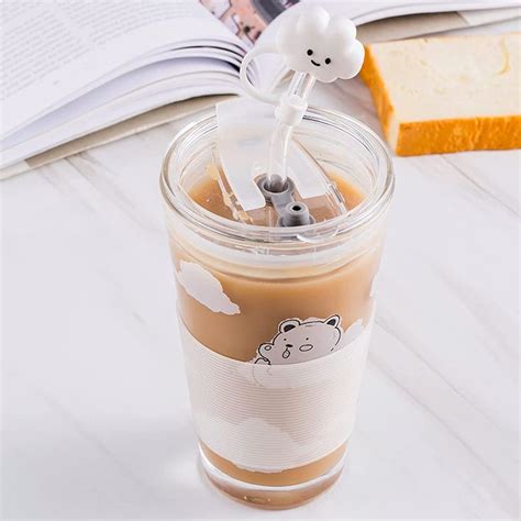 a cup filled with liquid sitting on top of a table next to an open book