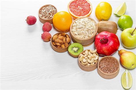 Groats, nuts, seeds, vegetables and fresh greens on a white wooden background. Top view ...