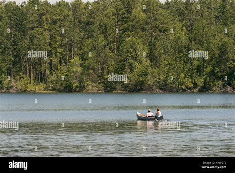 Visitors canoing on Flint Creek Reservoir at Flint Creek Water Park near Wiggins Mississippi USA ...