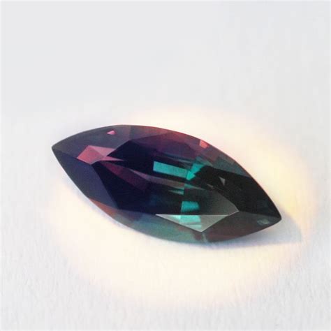 a purple diamond sitting on top of a white surface