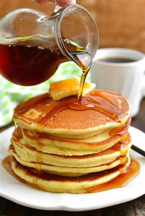 pouring maple syrup over a stack of pancakes out of a glass jar and a ...