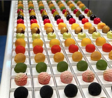 many different colored candies are lined up on a conveyor belt