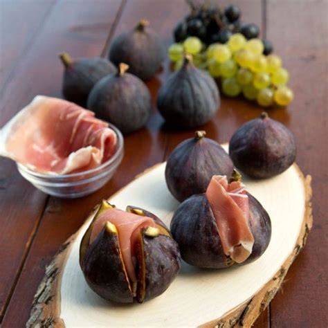 some figs are sitting on a wooden plate