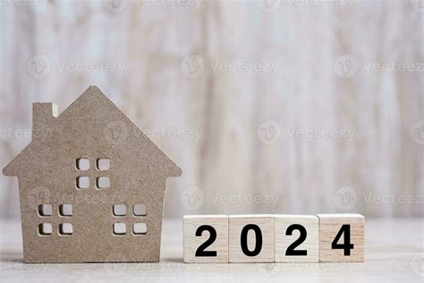 2024 Happy New Year with house model on table wooden background. Banking, real estate ...