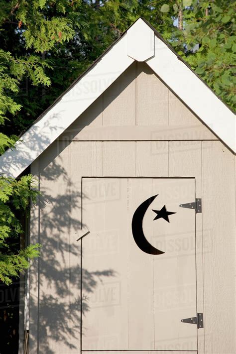 Close Up Of Wooden Outhouse With Crescent Moon And Star Cut Out On Door ...