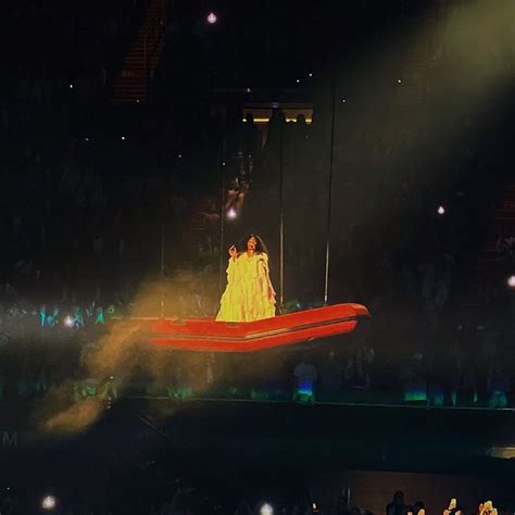 a woman standing on top of a red boat in the middle of a stage filled ...