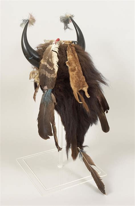 an animal's head with long horns and feathers on top of a clear acrylic stand