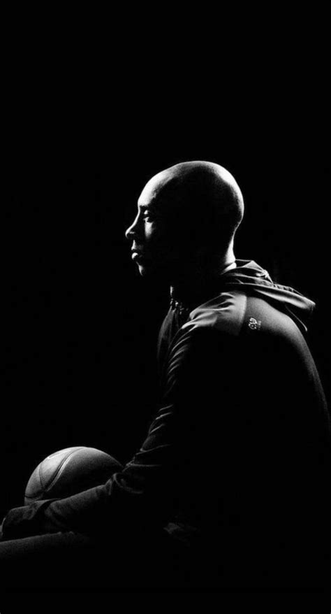 black and white photo of kobe sitting holding a basketball photographed ...