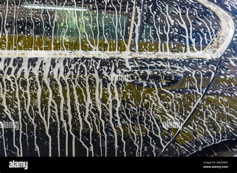 Wash the black car with foam at the car wash station Stock Photo - Alamy