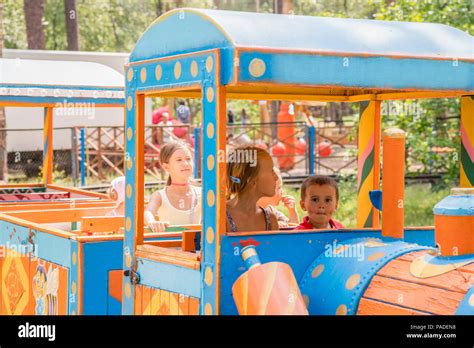 Four little children are riding on a children's train in the park Stock ...