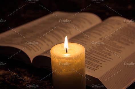 Candle illuminating the bible | Stock Photos ~ Creative Market