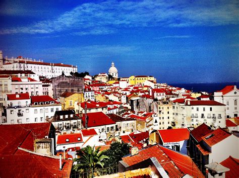 an aerial view of a city with red rooftops and white buildings in the foreground