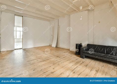 A Living Room with White Walls and a Black Couch Stock Image - Image of ...