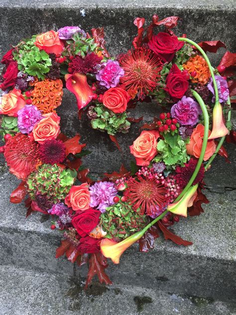 Funeral heart wreath in autumnal colours orange reds cerise flowers ...