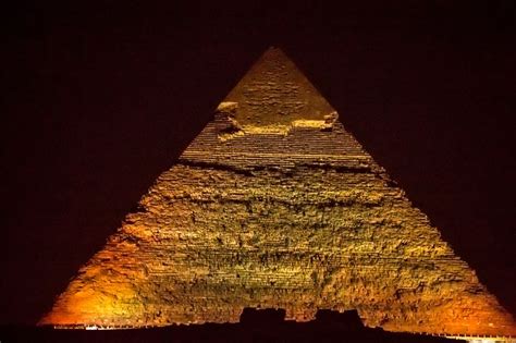 Pyramids at night - Pyramids of Giza in Egypt lit by spot lights in the evening during the light ...