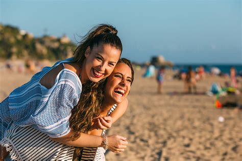 "Two Friends Laughing On The Beach" by Stocksy Contributor "VICTOR TORRES" - Stocksy