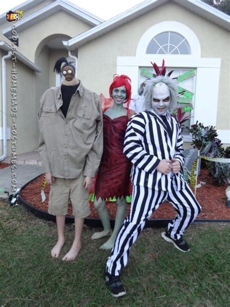 three people dressed up as clowns in front of a house