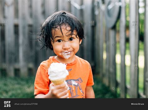 Portrait of a boy with a messy face holding an ice cream cone stock ...