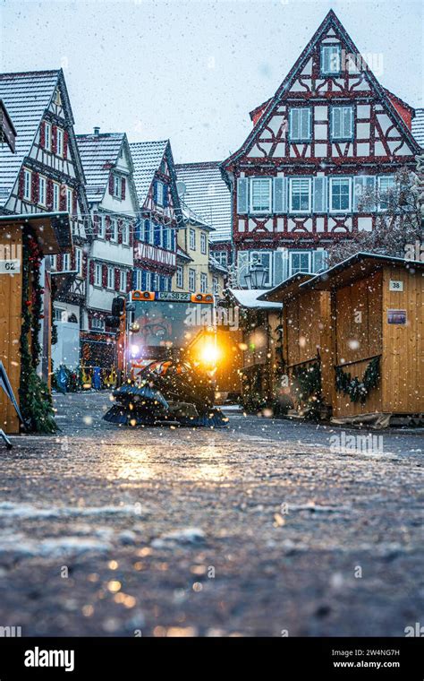 Christmas market in the snowfall with evening light illuminated by half ...