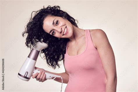 Foto Stock Young smiling curly haired woman follows the curly girl method with suitable curly ...