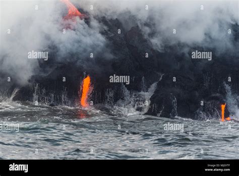 Streams of lava pour into the Pacific Ocean from Kilauea Volcano outside Volcanoes National Park ...