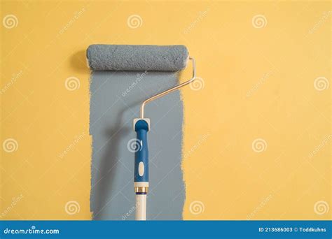 Paint Roller with Blue Paint on a Yellow Wall Stock Image - Image of redecorate, people: 213686003