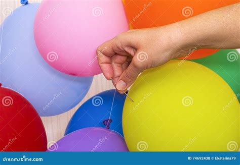 Woman Hand with Needle Ready To Pop a Yellow Balloon Stock Photo ...