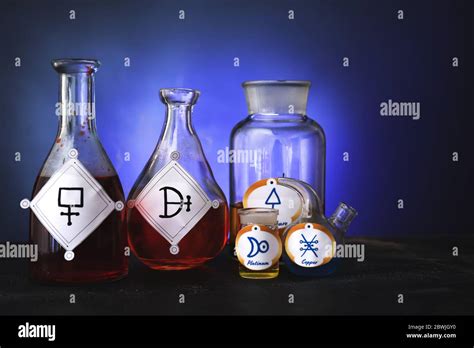 Potions with alchemical symbols on table Stock Photo - Alamy