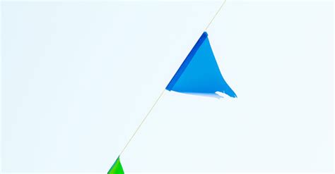 Multicolored string of pennant flags against blue sky · Free Stock Photo