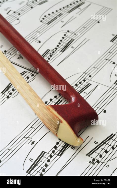 Violin bow tip on sheet music background Stock Photo - Alamy