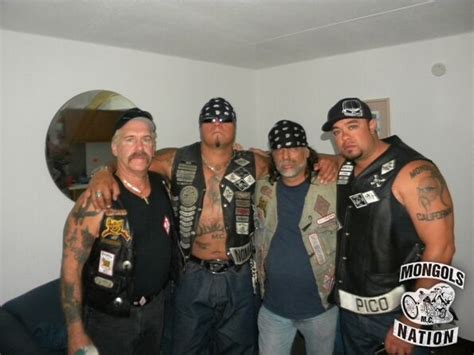 four men in leather vests and bandanas posing for a photo together with their arms around each other