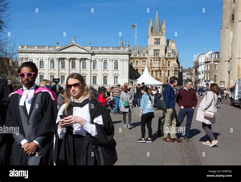 Cambridge University students wearing gowns on graduation day walking ...