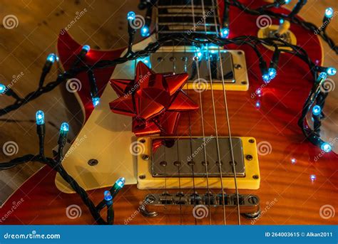 Guitar with Christmas Lights and Ribbon on a Wooden Table Stock Image ...