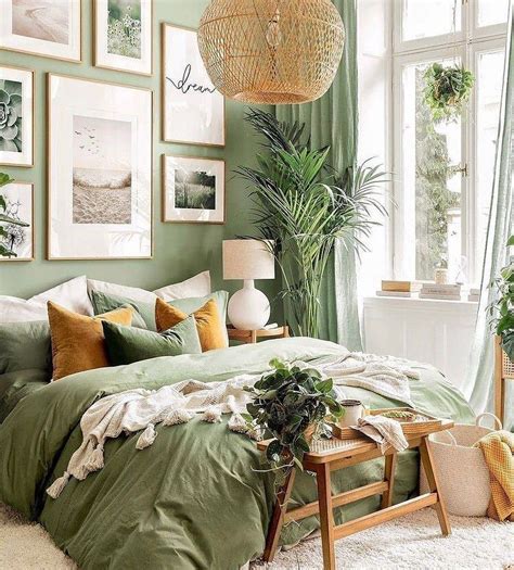 a bedroom with green walls and pictures hanging on the wall above the bed, along with a wicker ...
