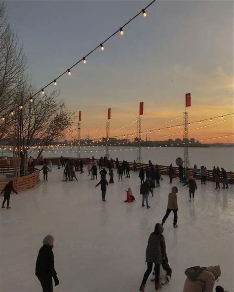 people skating on an ice rink at sunset