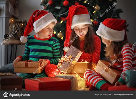 Cute little children opening magic Christmas gift at home Stock Photo ...