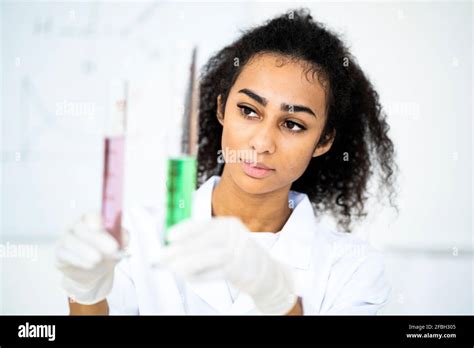 Female chemist examining liquid in test tubes while working in laboratory Stock Photo - Alamy