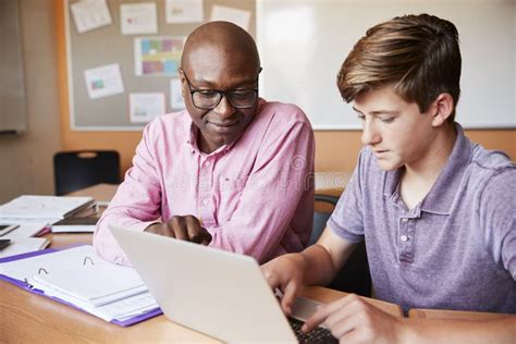 High School Tutor Giving Male Student One To One Tuition at Desk Stock Image - Image of pupil ...