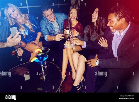 Party, social event and friends toast with champagne and alcohol on a night out in a nightclub ...