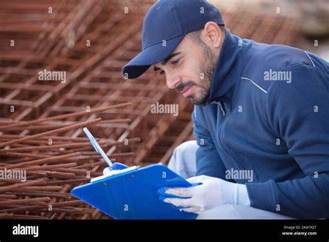 construction worker inspecting metal bar Stock Photo - Alamy