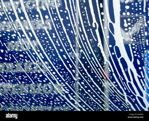 Soap suds making pattern on car windshield in car wash Stock Photo - Alamy