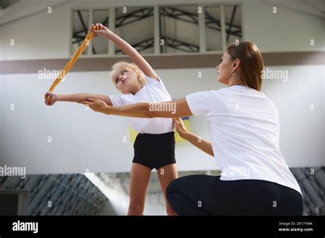 Coaching. Beginner gymnastics athletes doing exercises with gymnastics ...