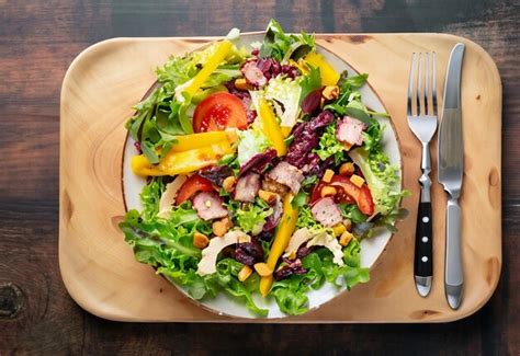 Premium Photo | A plate of salad with a fork and a plate of food on it.