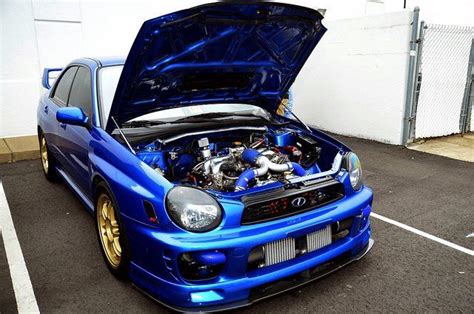 a blue car with its hood open in a parking lot