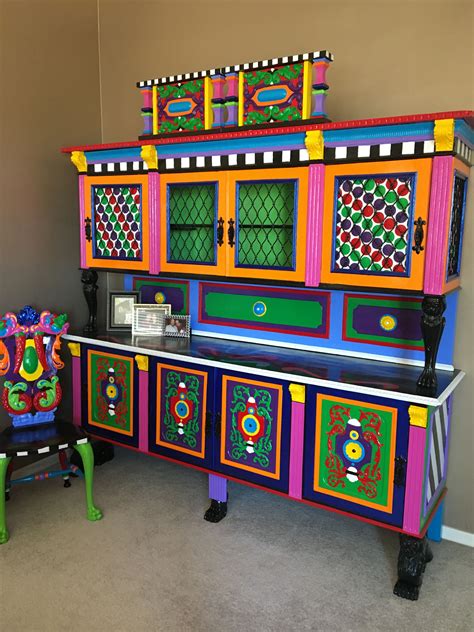 a brightly colored dresser and chair in a room